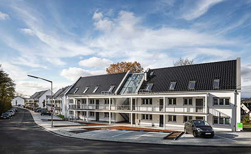 Auf dem Bild ist ein neu gebautes Mehrfamilien-Haus zu sehen.